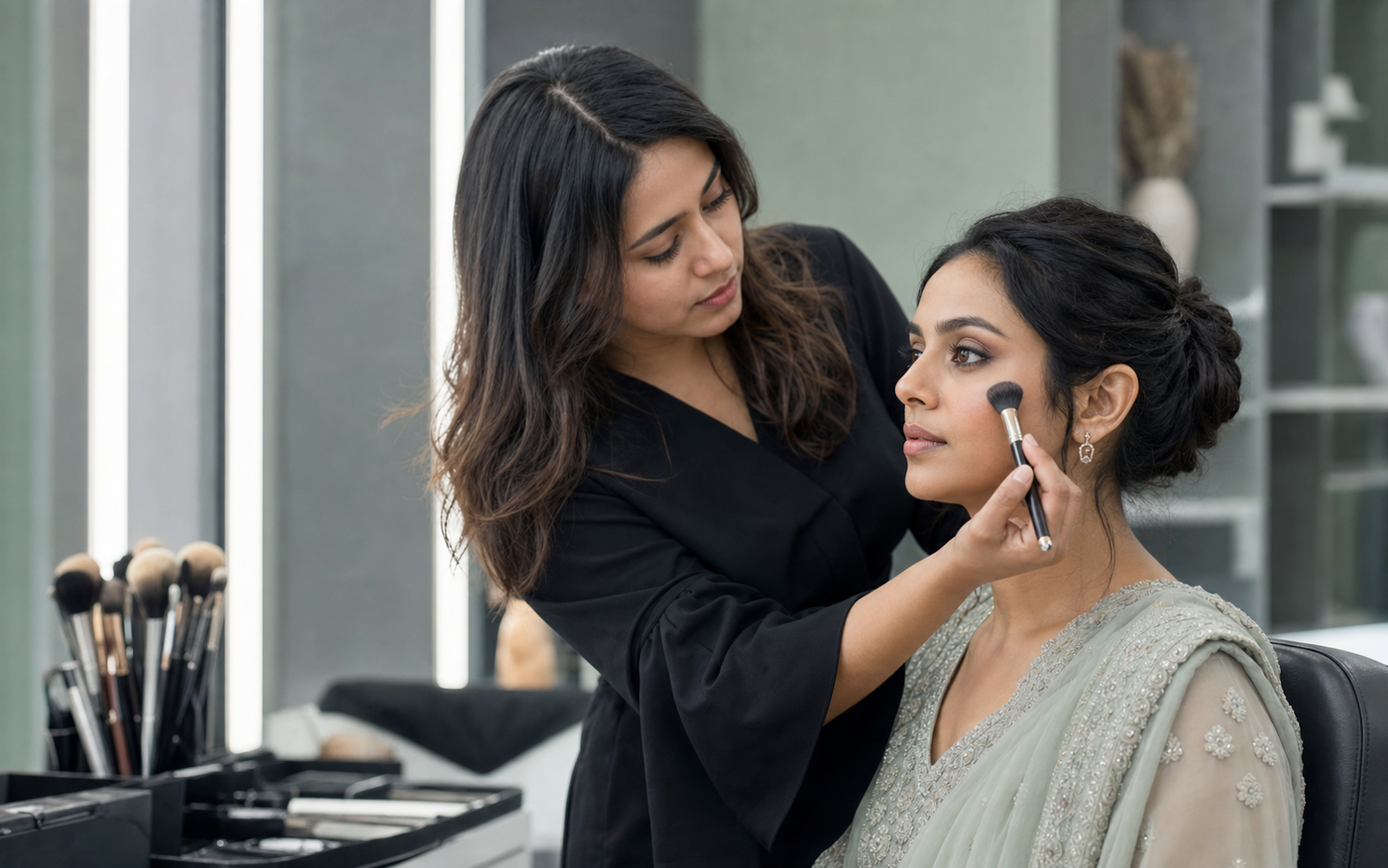 Makeup artist applying makeup with a brush to an Indian client in a contemporary salon