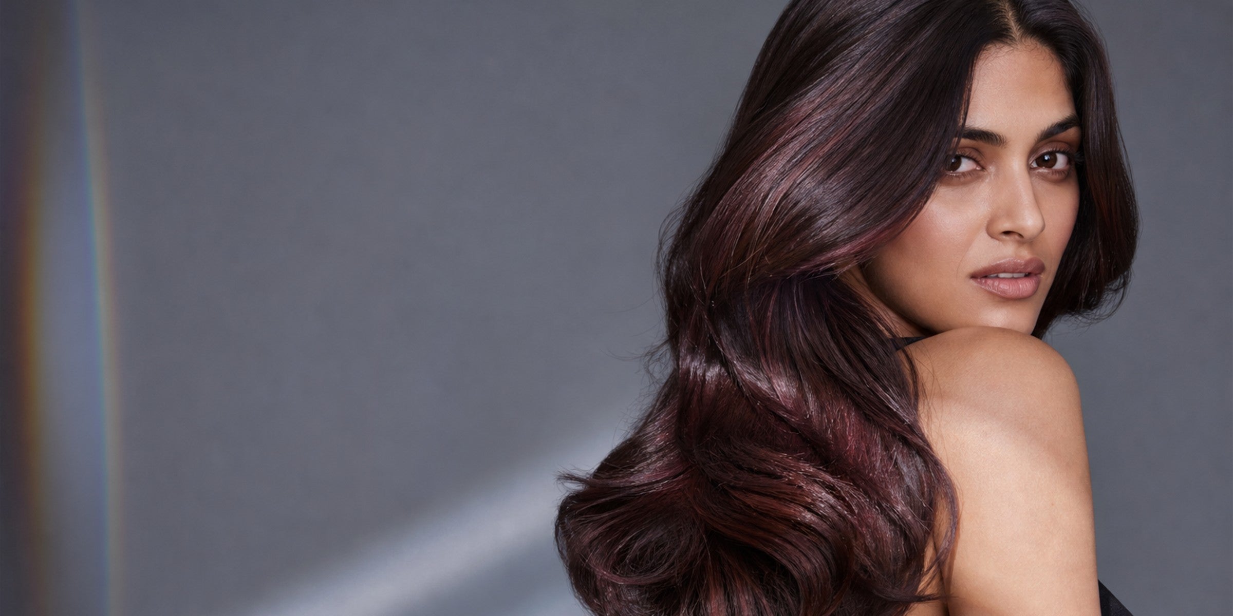 Mirror-gloss brunette hair with a clean band of light